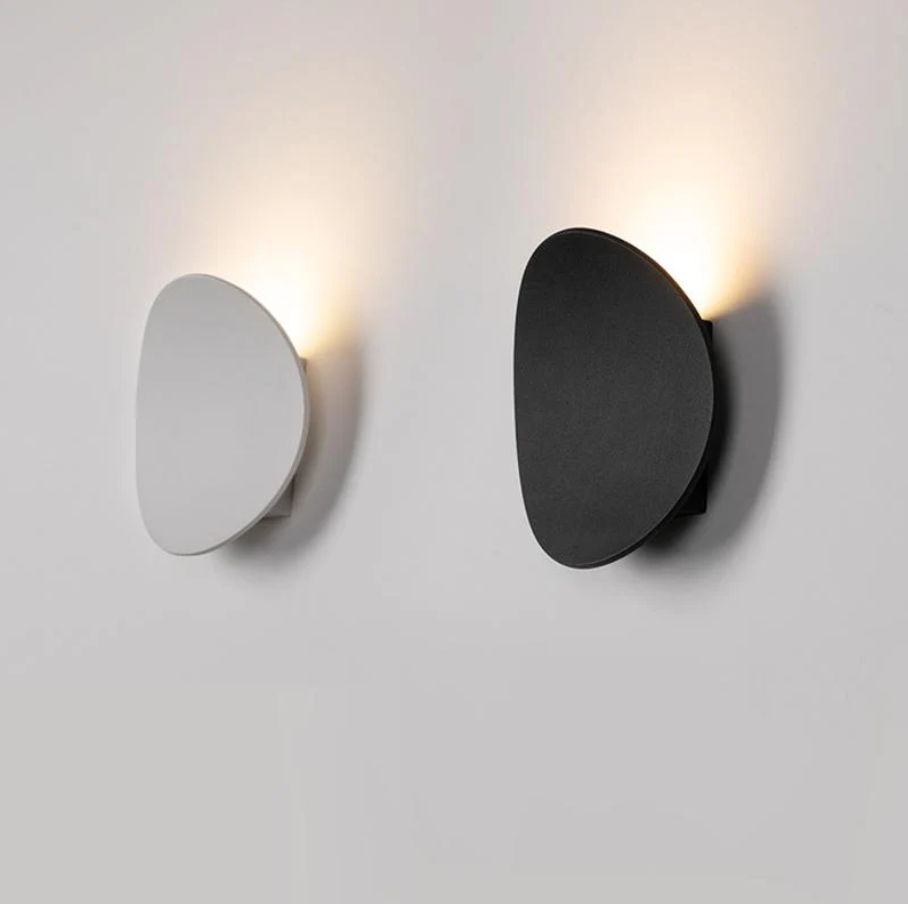 Brazzaville modern LED wall light in black and white finishes mounted on a wall with warm upward lighting