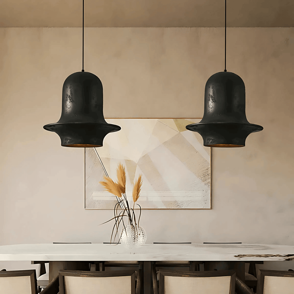 Two black Tunis pendant lights with bell-shaped resin shades hanging above a modern dining table