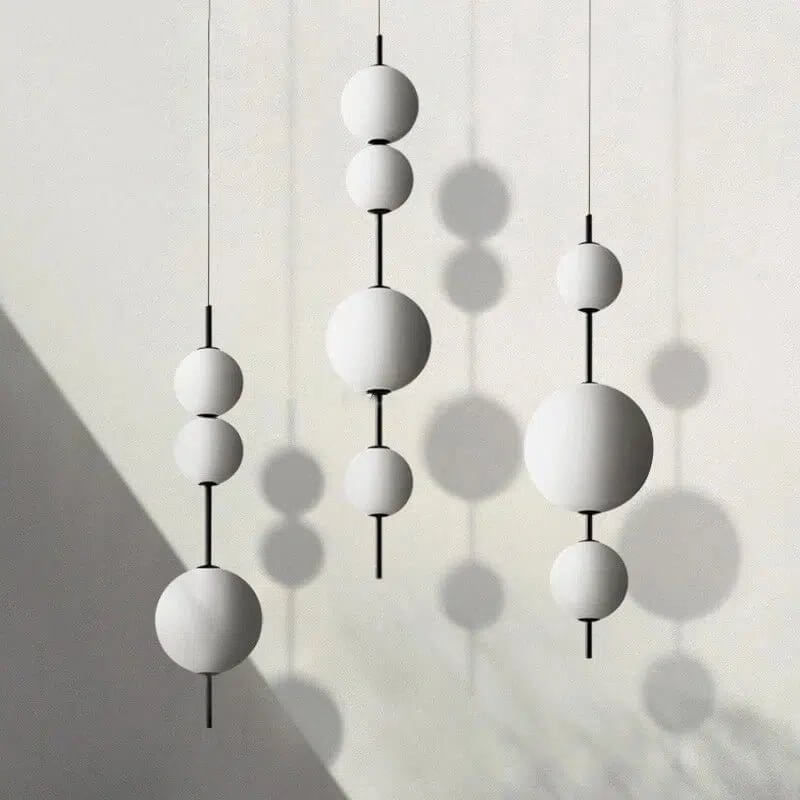 Bern pendant light with white glass globe shades in a modern hanging cluster design
