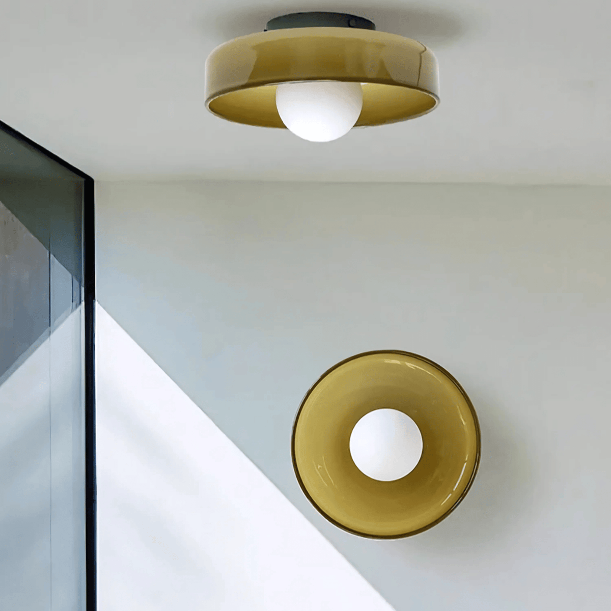Milan ceiling light in amber glass with round globe bulb, shown as matching ceiling and wall light