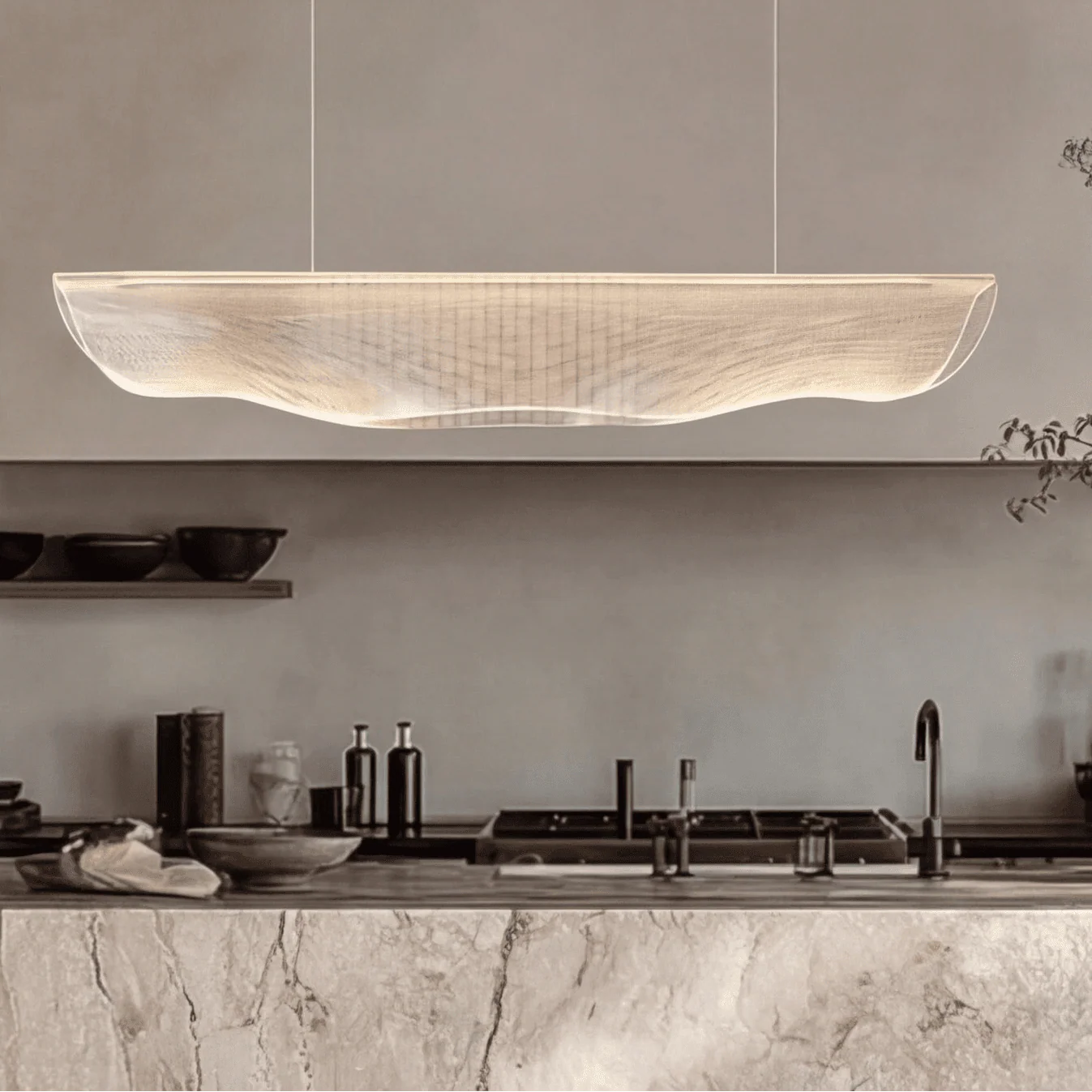 Moroni chandelier modern wave LED pendant light with acrylic shade suspended above a minimalist kitchen island