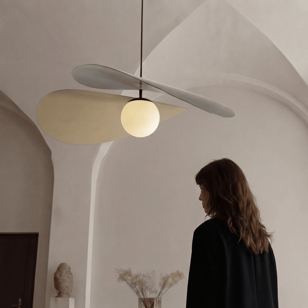 Arbil modern pendant light with curved metal shades and frosted glass globe in a minimalist interior