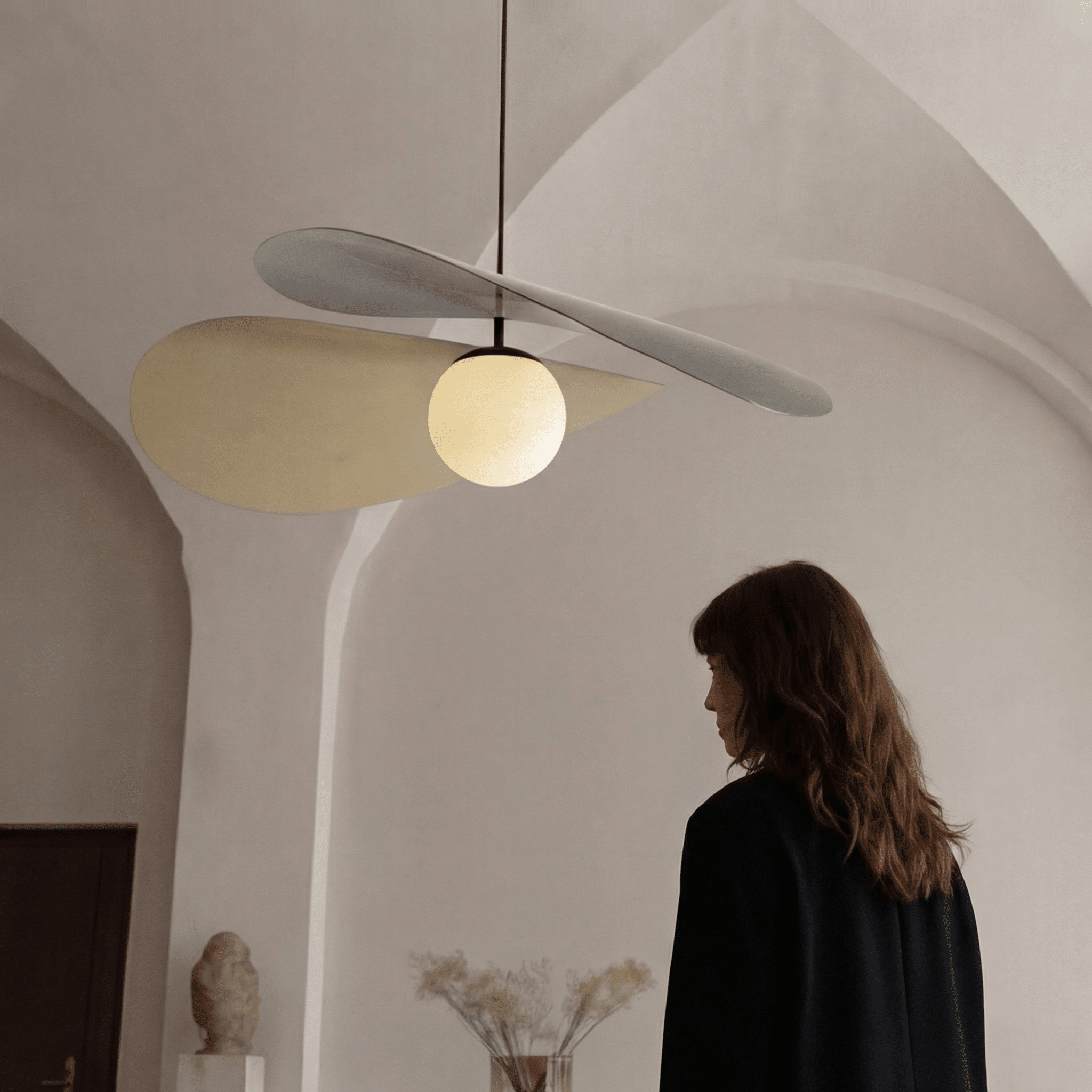 Arbil modern pendant light with curved metal shades and frosted glass globe in a minimalist interior