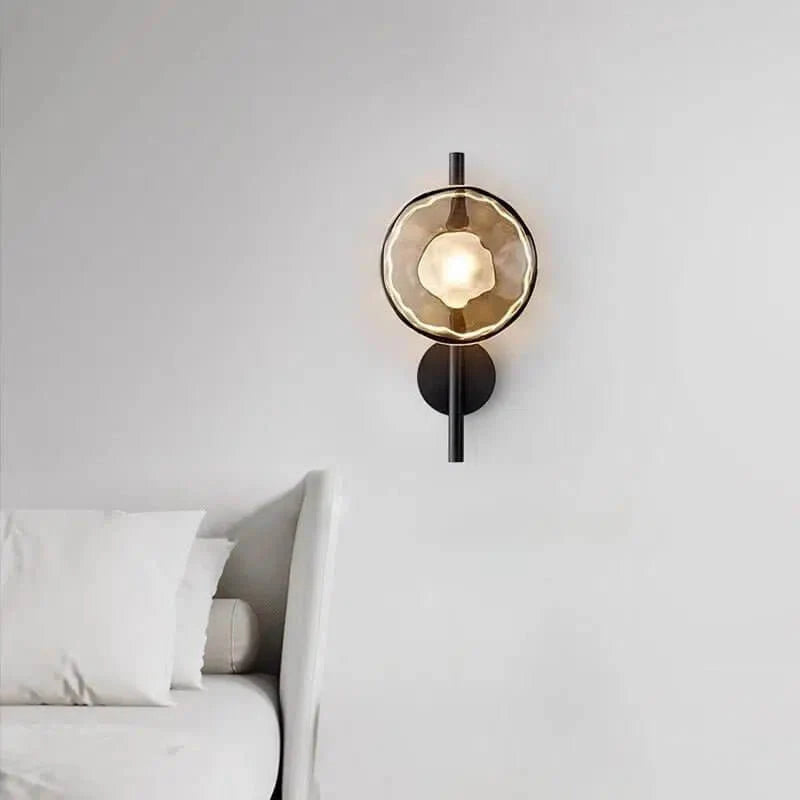 Wellington modern wall light with black metal frame and organic glass shade mounted beside a bed