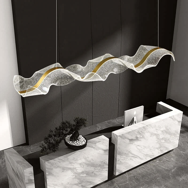 Modern wave acrylic LED chandelier with textured finish above a marble reception desk