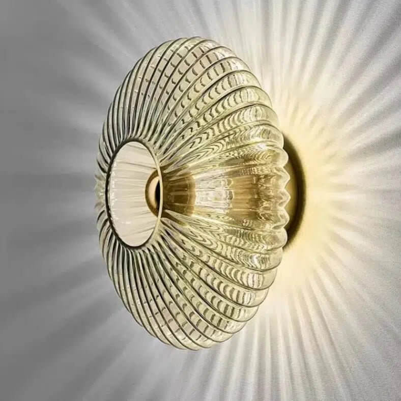 London wall light with ribbed glass shade casting a decorative sunburst glow on the wall
